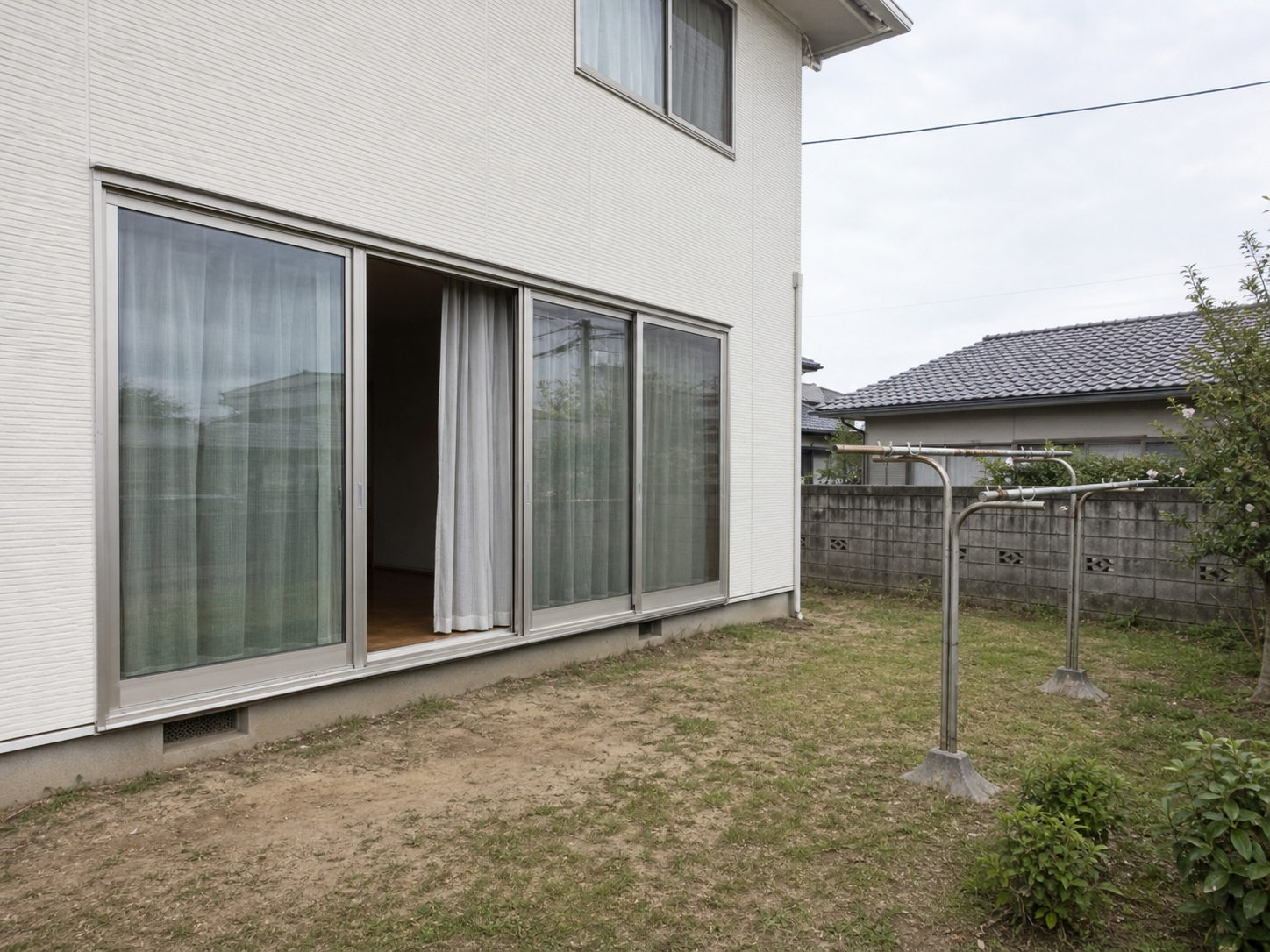 工事の前。掃き出し窓の前は屋根のない地面で、物干しスタンドが雨ざらしになっている